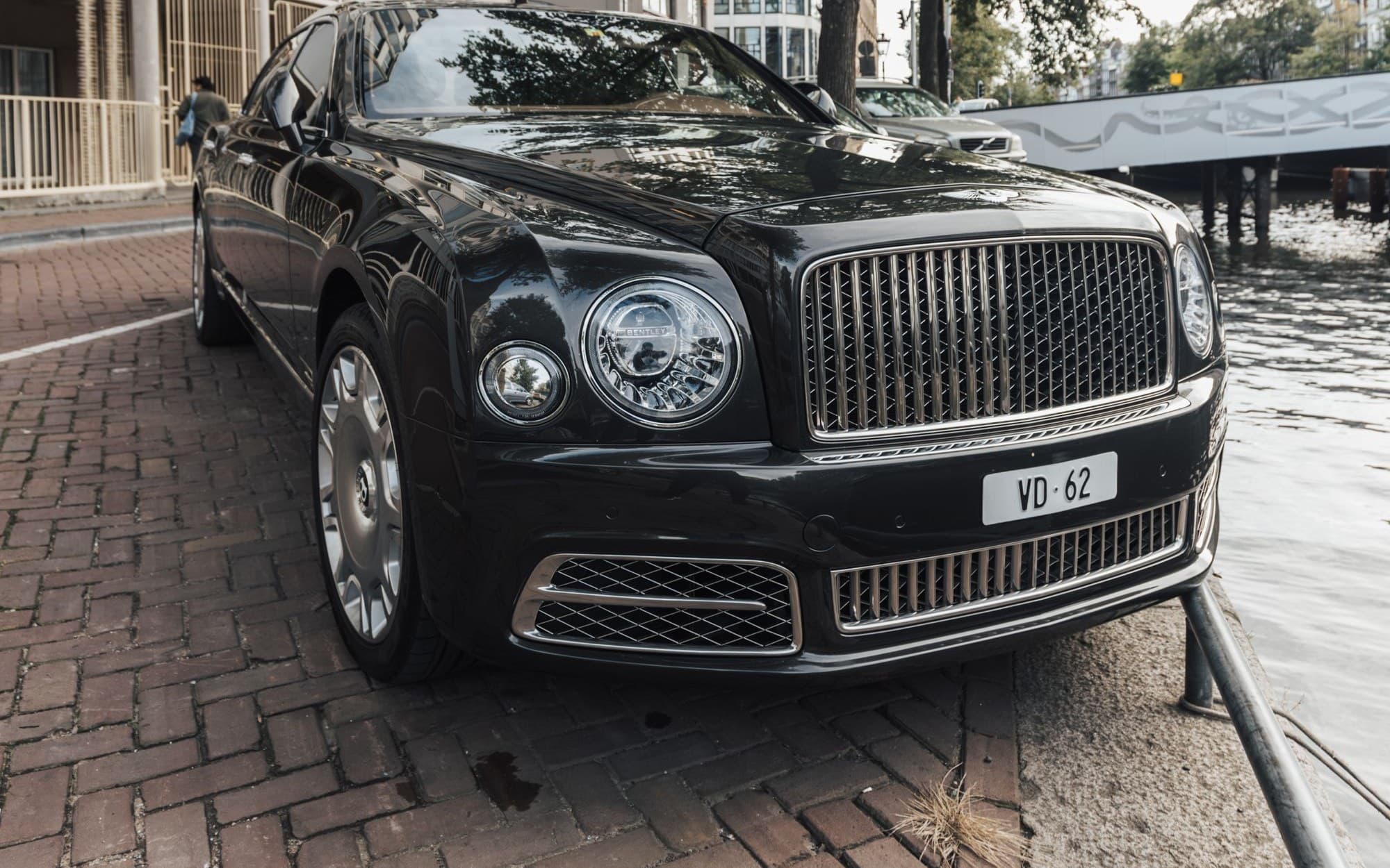 Black Bentley Mulsanne parked beside a city canal
