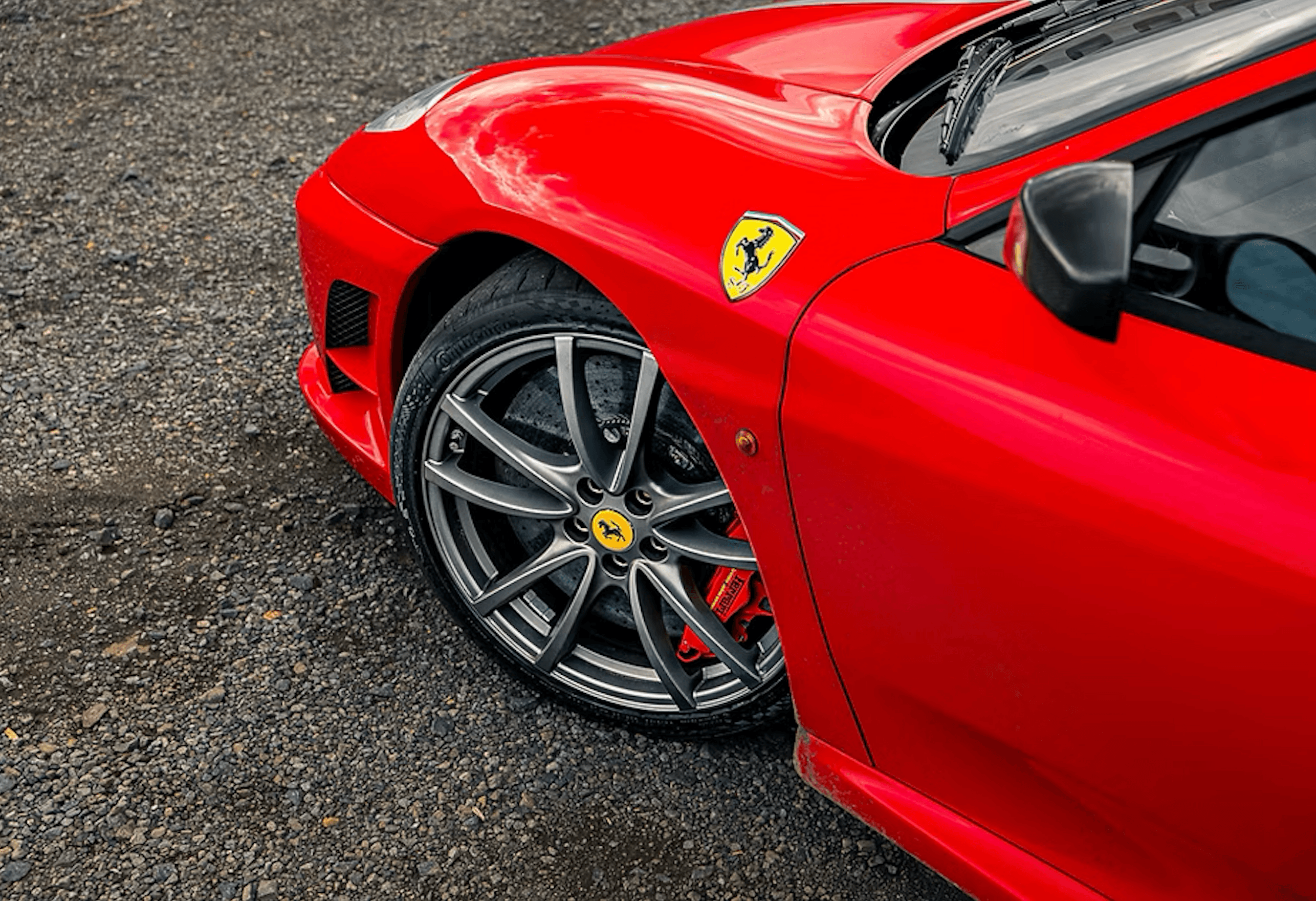 Front wheel and fender detail of a red Ferrari F430