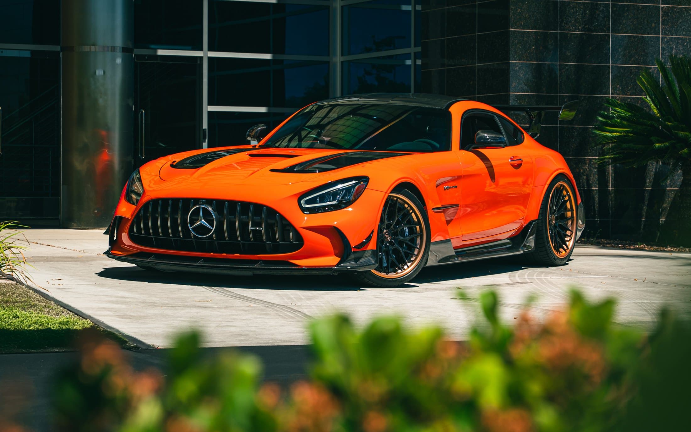Orange Mercedes-AMG GT Black Series outside a modern glass building
