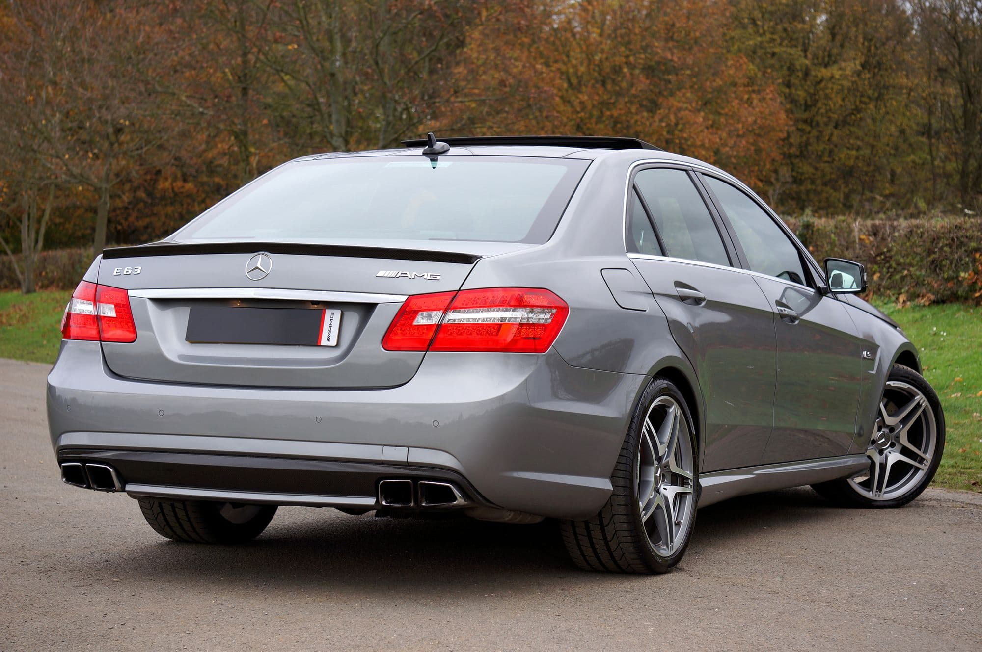 Silver Mercedes-AMG E63 parked on a tree-lined country road