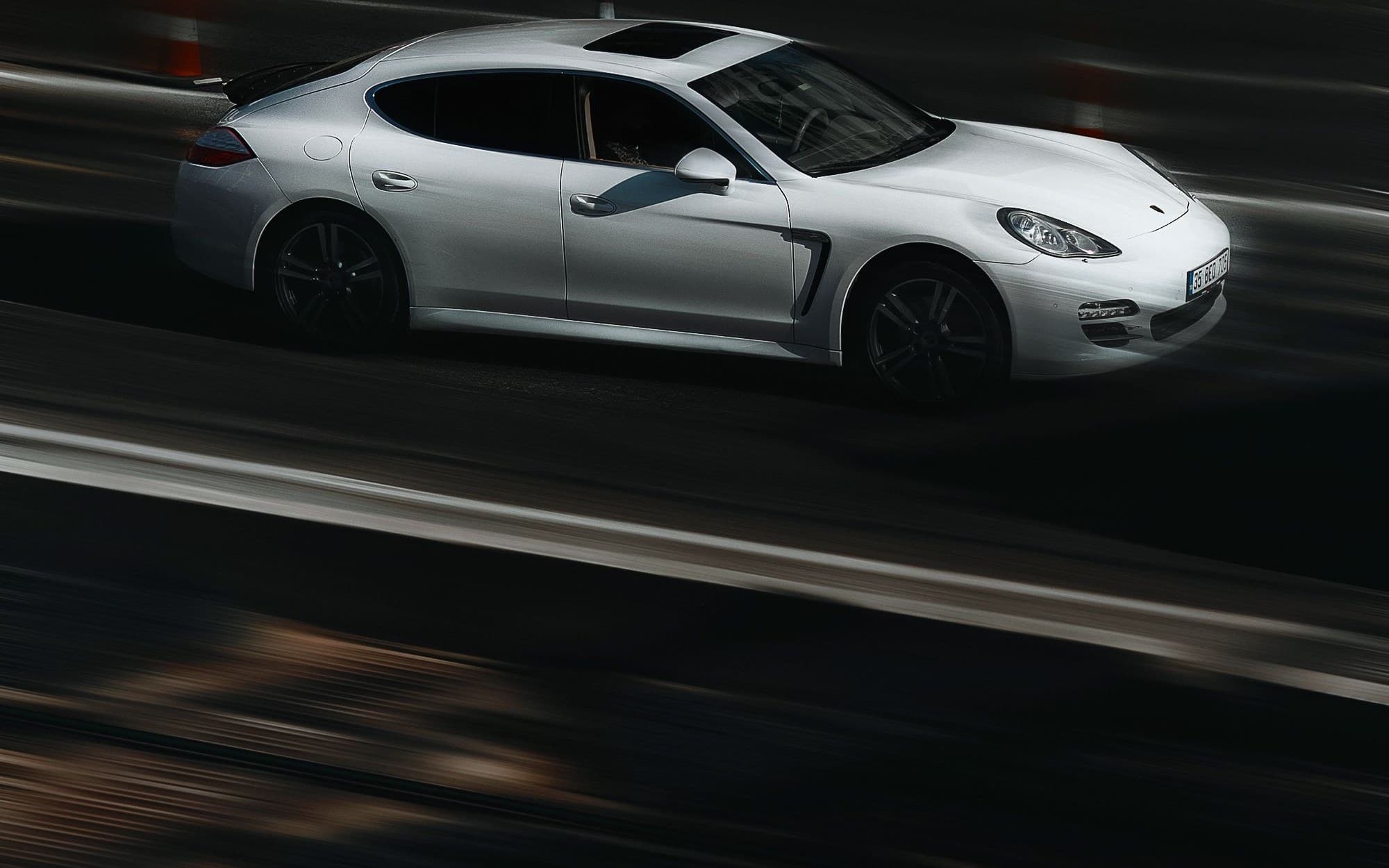 White Porsche Panamera driving through a dark city street